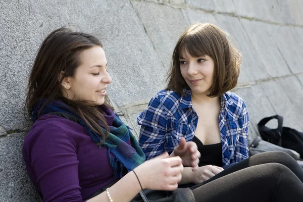 Urban teen girls sitting at stone wall — Stock Photo, Image