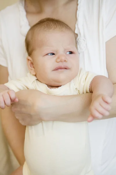 Anne eller üzerinde oturan küçük sarışın kız — Stok fotoğraf