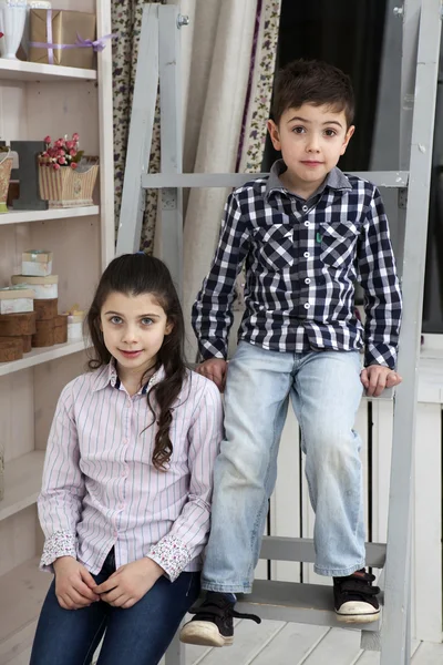 Portrait of a cute little boy and sister sitting on the staircas — Stock Photo, Image