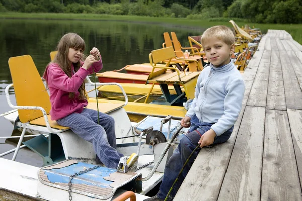 Venskab. Børn leger i gul båd. Sommertid - Stock-foto