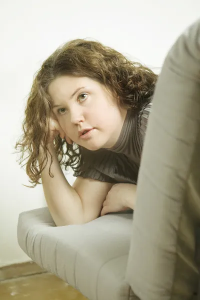 Girl lying on sofa. Girl  face look out from sofa — Stock Photo, Image