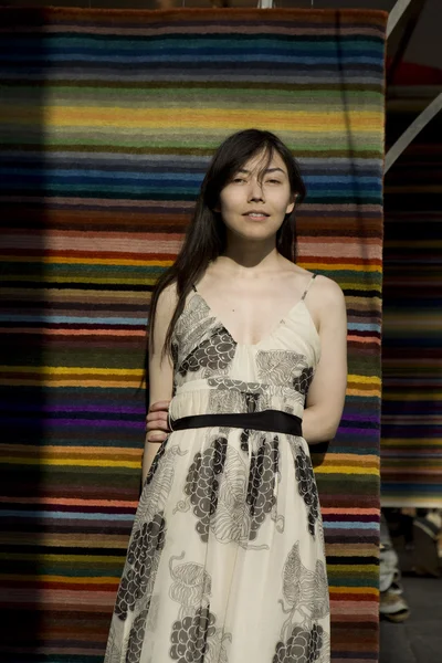 Attraktiva flicka i fashionabla klänning nära vägg — Stockfoto