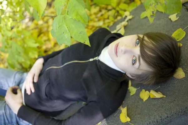 Young beautiful girl among the yellow autumn leaves — Stock Photo, Image