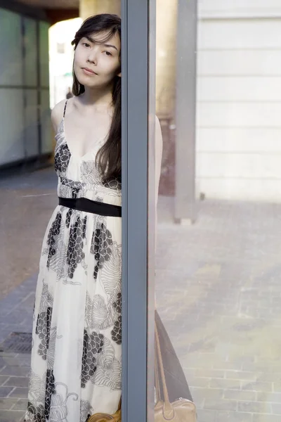 Attraktiva flicka i fashionabla klänning nära vägg — Stockfoto