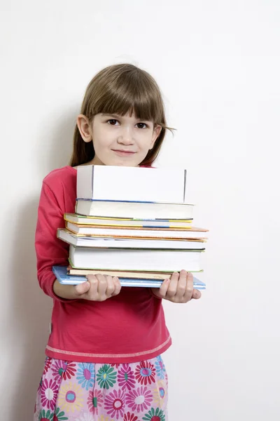 Niña linda siete años de edad llevar libros. Fondo blanco —  Fotos de Stock