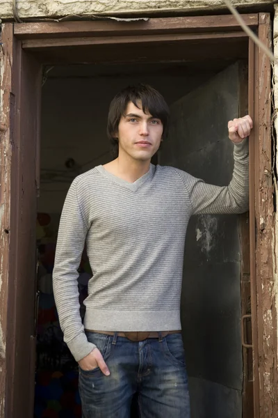 Young attractive man standing at door stud — Stock Photo, Image