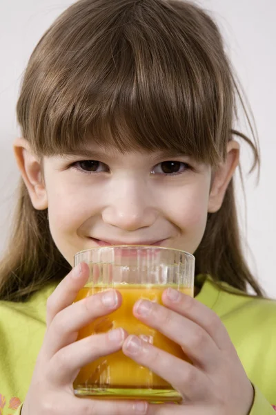Pequeña linda chica beber jugo de naranja — Foto de Stock