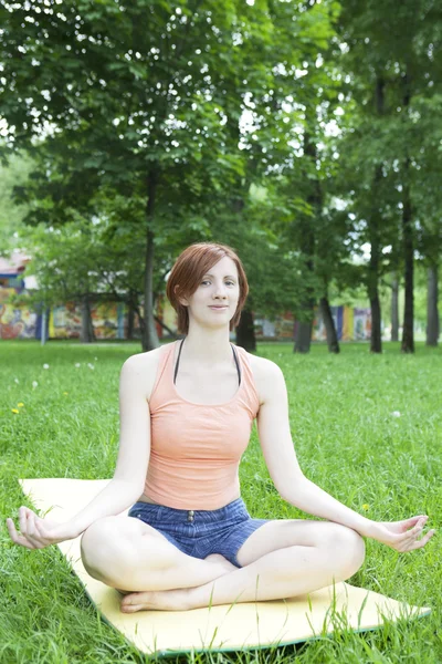 Jovem mulher meditando em um parque — Fotografia de Stock