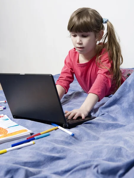 Menina bonito sete anos de idade brincando com o computador — Fotografia de Stock