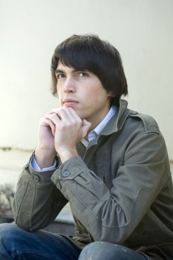 Kapının önünde oturan ciddi yakışıklı adam portresi.