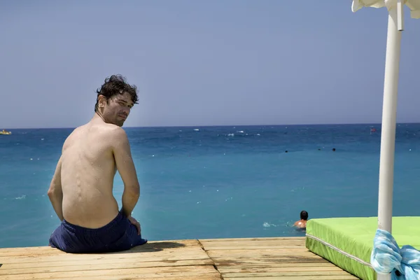 Hombre sentado en el muelle — Foto de Stock