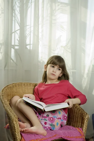 坐在小可爱严重女孩七岁读本书 — 图库照片