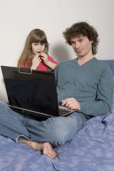 Far och dotter spelar spelet med laptop — Stockfoto