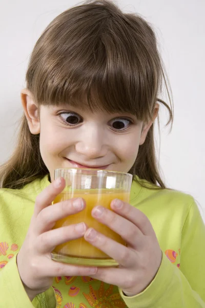 Dívka pít pomerančový džus — Stock fotografie