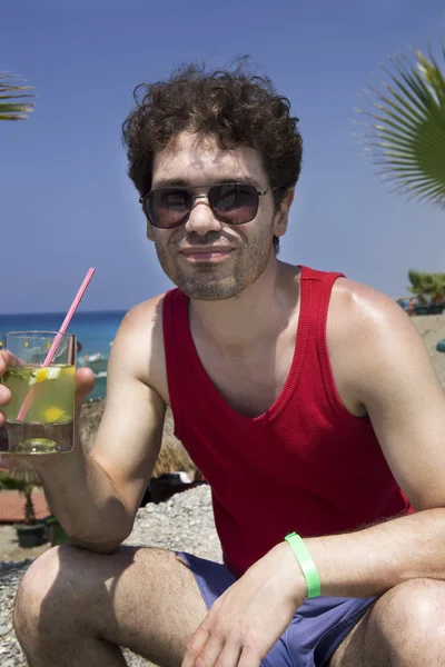 Человек в очках пьет коктейль Мохито — стоковое фото