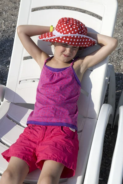 Girl lying on chaise longue — Stock Photo, Image