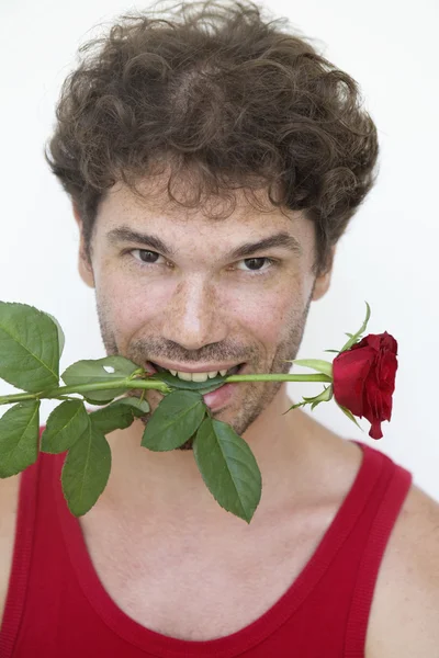 Hombre con una rosa roja en la boca — Foto de Stock