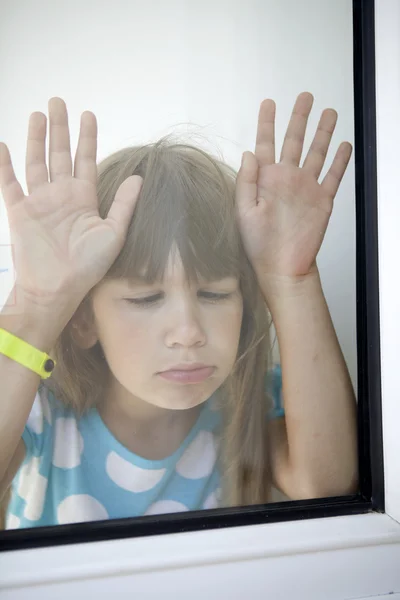 Petite fille regardant par la fenêtre — Photo