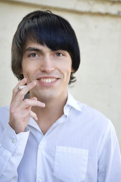 Närbild porträtt av unga miling stilig smoking man — Stockfoto
