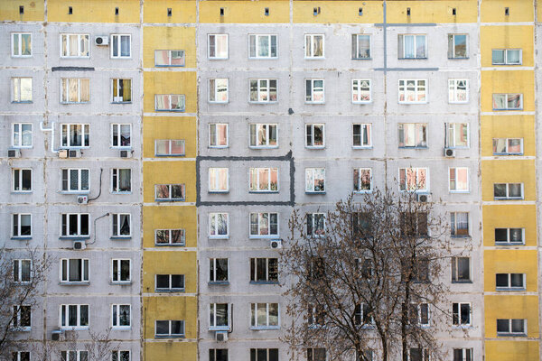 The facade of a nine-storey block house with yellow stripes. Moscow