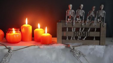 Cadılar Bayramı. İskelet dolu bir kutuyla dekore edilmiş bir şöminede mum yakmak.