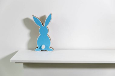 Mavi tavşan beyaz çekmecelerin üzerinde. Paskalya dekorasyonu.