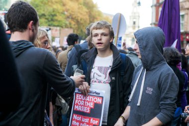 Londra, İngiltere - 19 Kasım 2017: Öğrenciler eğitim sistemindeki kesintilere ve ücretlere karşı bir protesto yürüyüşüne katıldılar. Genç adam bir poster tutuyor - kitleler için eğitim