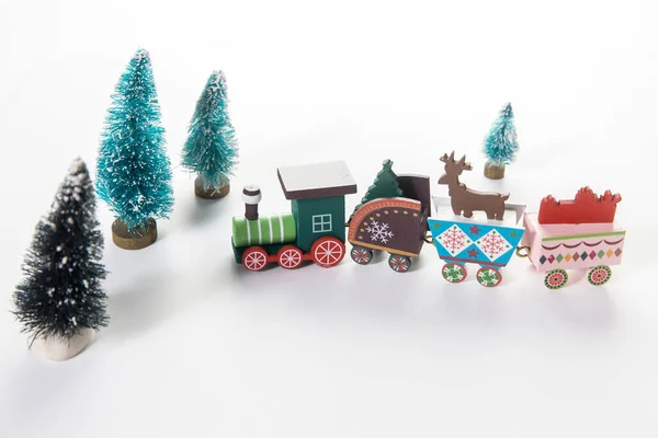 Spielzeugeisenbahn Mit Hirsch Und Ornamenten Neben Künstlichen Miniatur Weihnachtsbäumen Auf — Stockfoto