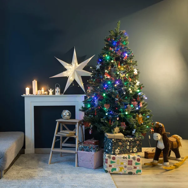 Hausdekoration Vor Weihnachten Geschmückter Weihnachtsbaum Mit Lichtergirlanden Schaukelpferd Elegantes Papier — Stockfoto