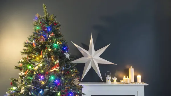 クリスマス前の家の装飾 ガーランドライト ロッキングホース エレガントな紙に包まれた贈り物 大きな白い紙の星とキャンドルを持つ人工暖炉で飾られたクリスマスツリー — ストック写真