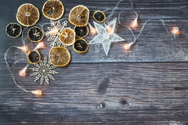 Gedroogde Sinaasappelschijfjes Draadsterren Gesneden Sneeuwvlokken Bloemenslinger Een Houten Tafel Plaats — Stockfoto