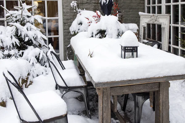 白雪覆盖的阳台 桌子上有一束干枯的枝条 上面挂满了越橘 — 图库照片