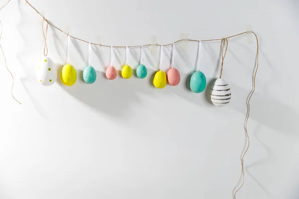 Una Guirnalda Huevos Plástico Multicolores Colgando Una Pared Blanca Decoración — Foto de Stock