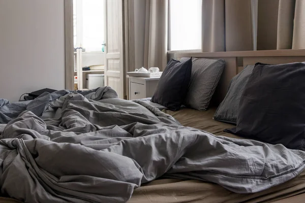 グレーのデュベットカバーに2つのデュベットが付いた未加工のベッド 朝のコンセプト — ストック写真