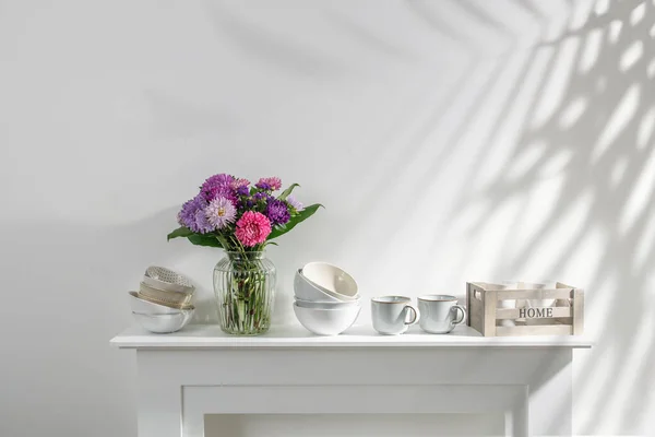 キッチン用品 カップ ボウル ボトル 収納アイテム キャスターの花束は白いドレッサーにあります — ストック写真
