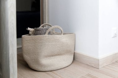 Tüvit ekose kumaş bir sepetin içinde beyaz duvarın yanında.