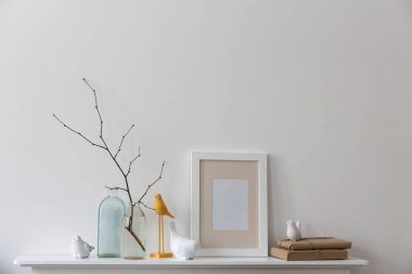 İskandinav tarzı. Dallı bir şişe su, farklı şekillerde iki boş şişe, beyaz bir şöminenin üzerinde kuş heykelcikleri. Boşluğu kopyala