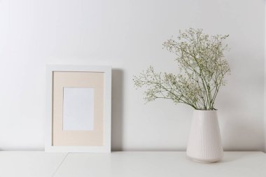 Boş tuval çerçeve modeli. İç dizayn üzerine sanat eserleri. Modern İskandinav tarzı iç mekan manzarası. Duvarda resim ya da poster için tuval var. Oturma odası, vazolarla dolu tuvalet. Minimalizm kavramı