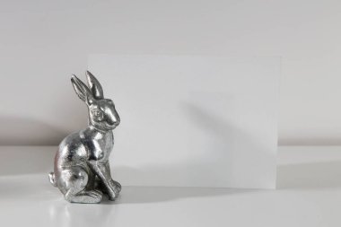 Rafta modern seramik paskalya tavşanı dekoru olan beyaz çerçeve. Beyaz renk şeması. Peyzaj çerçeve yönelimi.