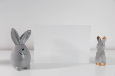 Rafta modern seramik paskalya tavşanı dekoru olan beyaz çerçeve. Beyaz renk şeması. Peyzaj çerçeve yönelimi.