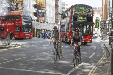 Londra, İngiltere - 20 Eylül 2021, Bir kadın ve bir erkek arabaların arasında bisiklet sürüyor