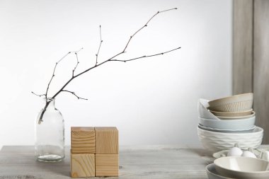 Cam vazoda patlamamış bir ıhlamur dalı ve yazı için yeri olan dört tahta küp. İskandinav tarzı. Metni kopyala