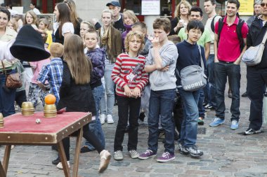 Londra, İngiltere - 20 Eylül 2021, Covent Garden 'daki sihirli bir köşede bir sihirbazın gösteri yapmasını izleyen bir grup çocuk.