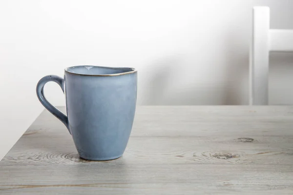 Una Taza Cerámica Azul Sobre Una Mesa Beige Contra Una — Foto de Stock