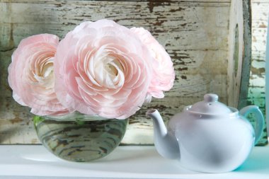 Beyaz pencere pervazında şeffaf yuvarlak vazoda üç soluk pembe ranunculus. Uzayı kopyala Metin için yer