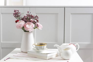 Bir sandık dolusu pembe İran düğün çiçeği beyaz bir masanın üzerinde çekmecenin önünde. İskandinav tarzı. Metin için yer