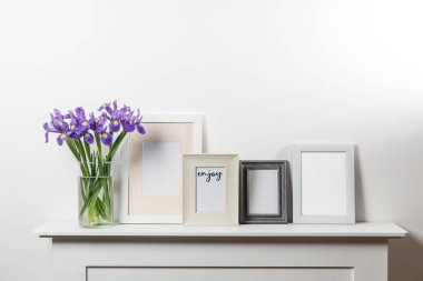 Vazoda süsen çiçekleri, çekmecede fotoğraf çerçeveleri.