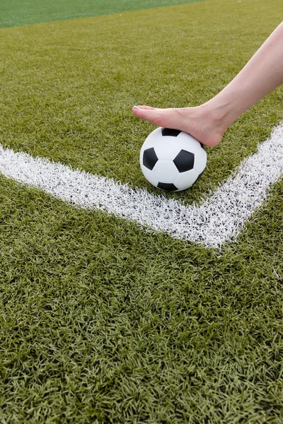 Menina pé na bola de futebol no campo verde — Fotografia de Stock