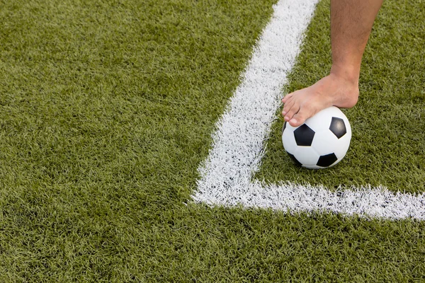 Homem pé na bola de futebol no campo — Fotografia de Stock