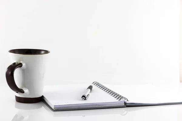 Tasse Kaffee und Notizbuch isoliert auf weißem Hintergrund — Stockfoto